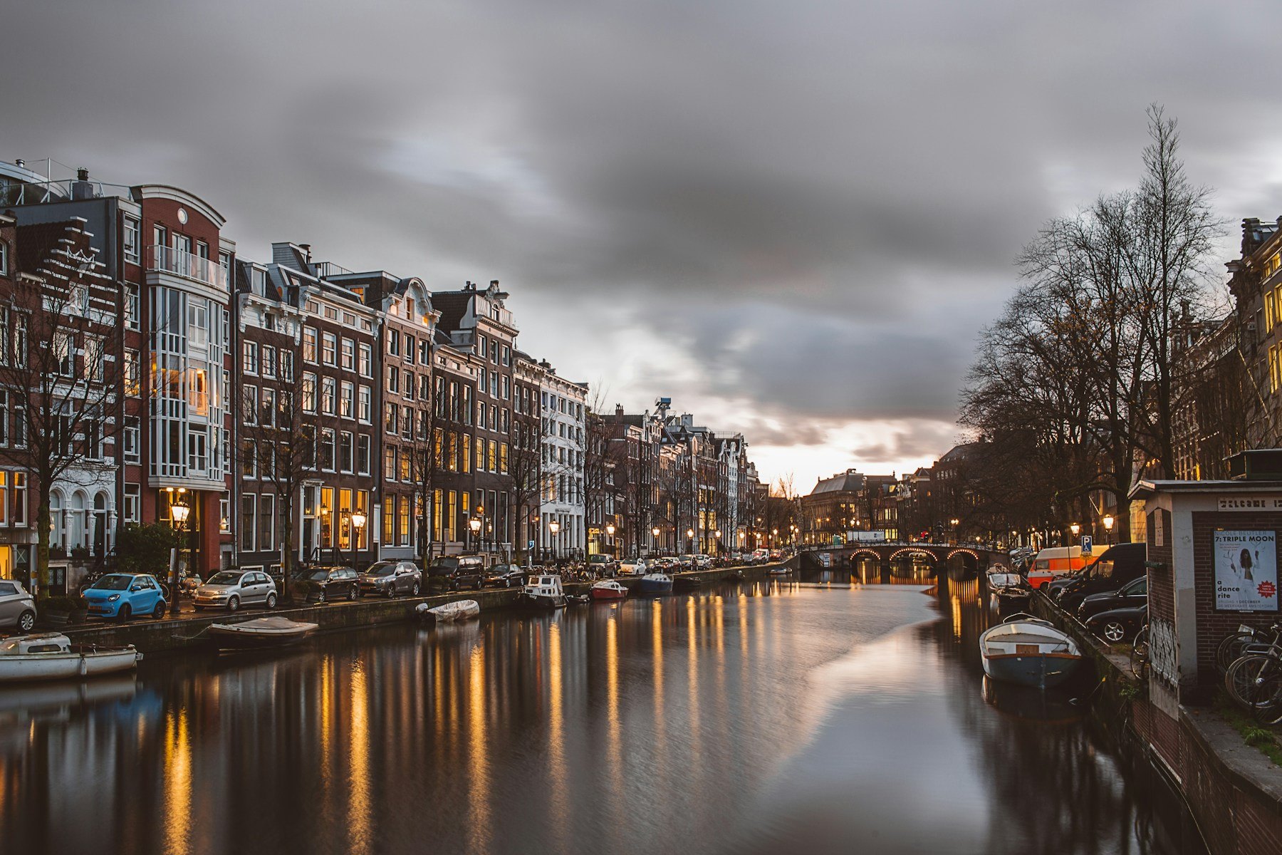 Amsterdam canal lined with historic buildings at dusk