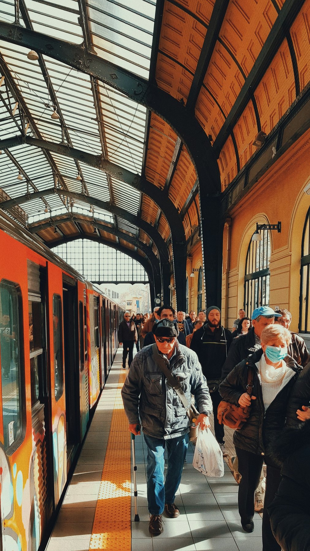 Passengers beside a train in an Athens Metro station