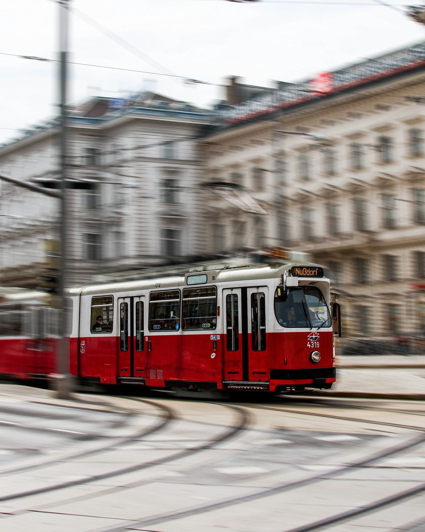 Red tram travelling along a Vienna street