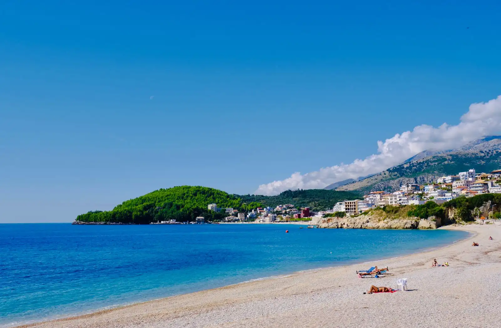 The beach and coastal buildings of Himarë beside blue water