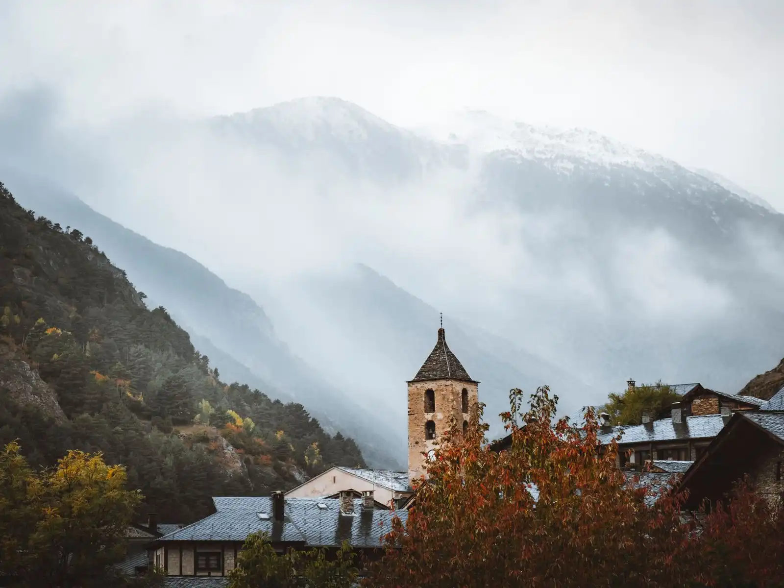 Ordino's church tower below misty mountains