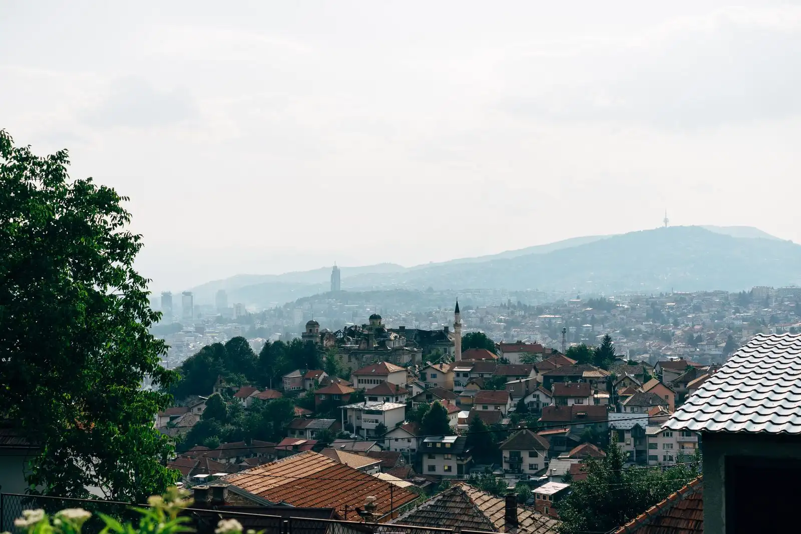 Sarajevo's rooftops across the valley below wooded hills