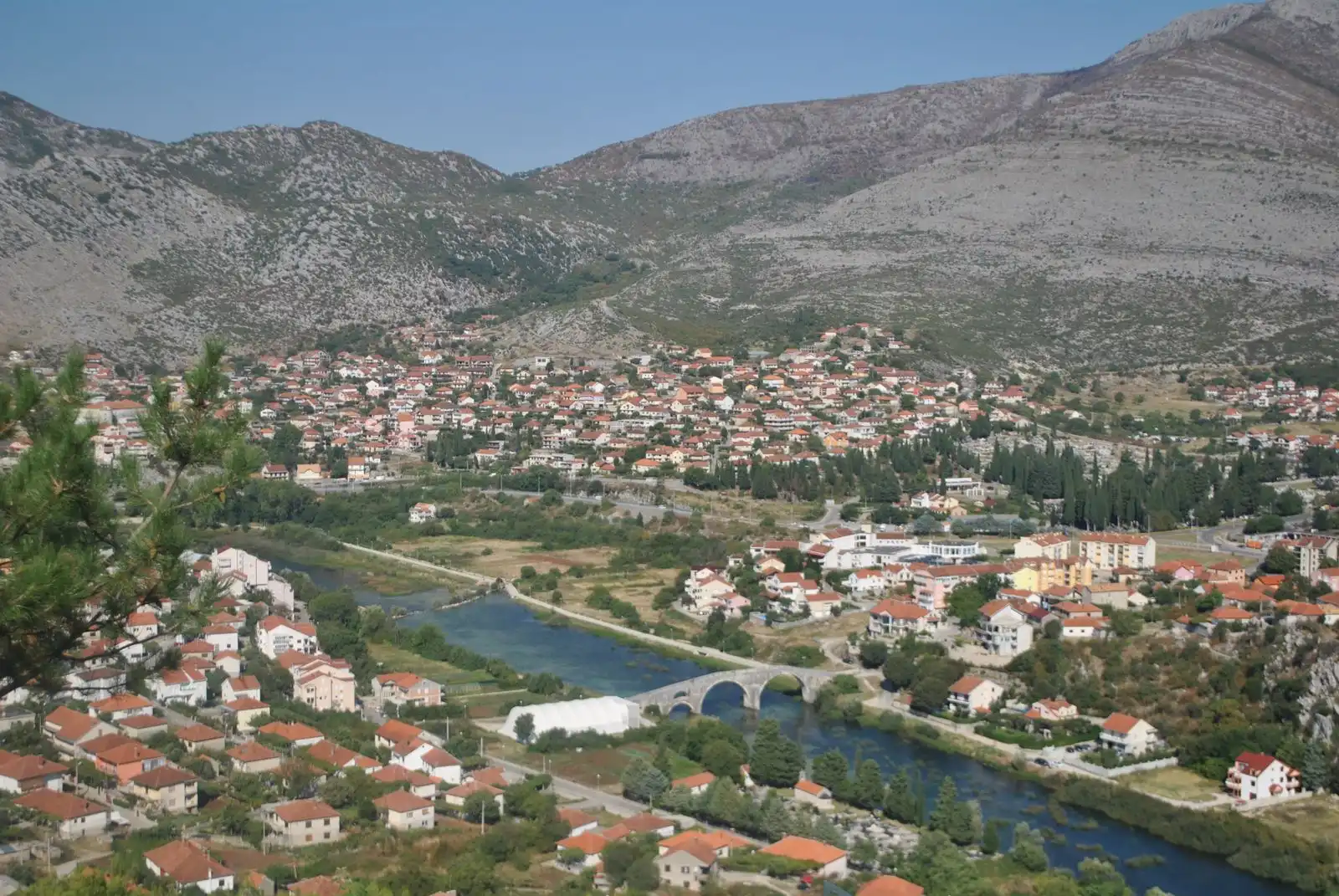 Trebinje's buildings and river below the surrounding hills