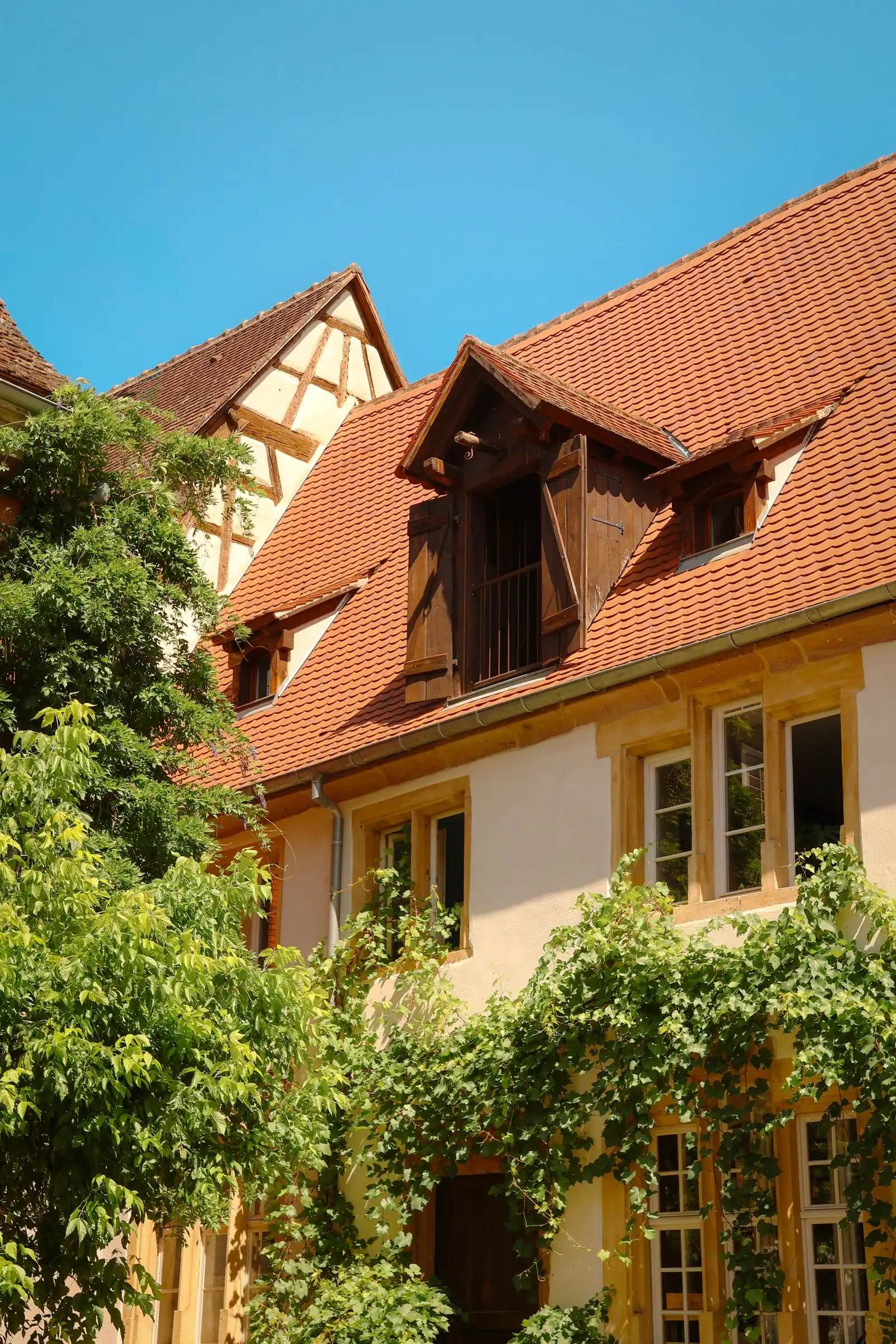 A tiled roof and flower-lined house in Riquewihr, Alsace