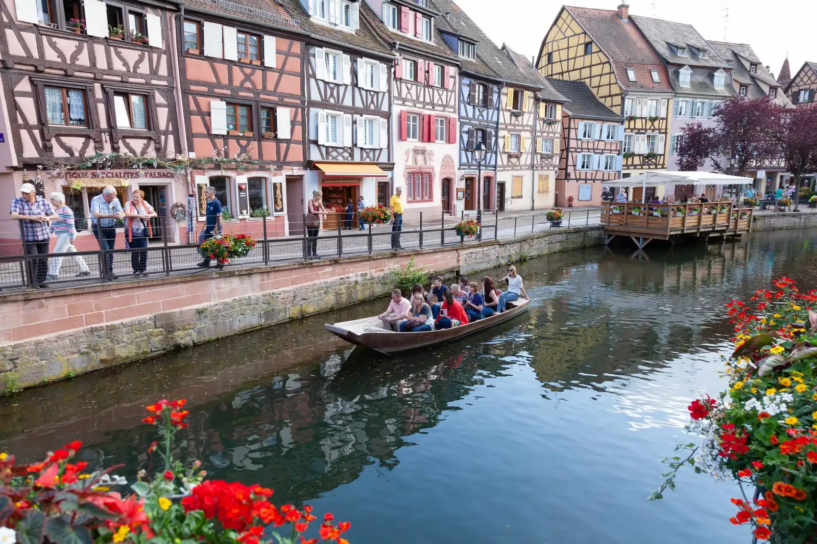A boat on a canal beside Colmar's half-timbered houses