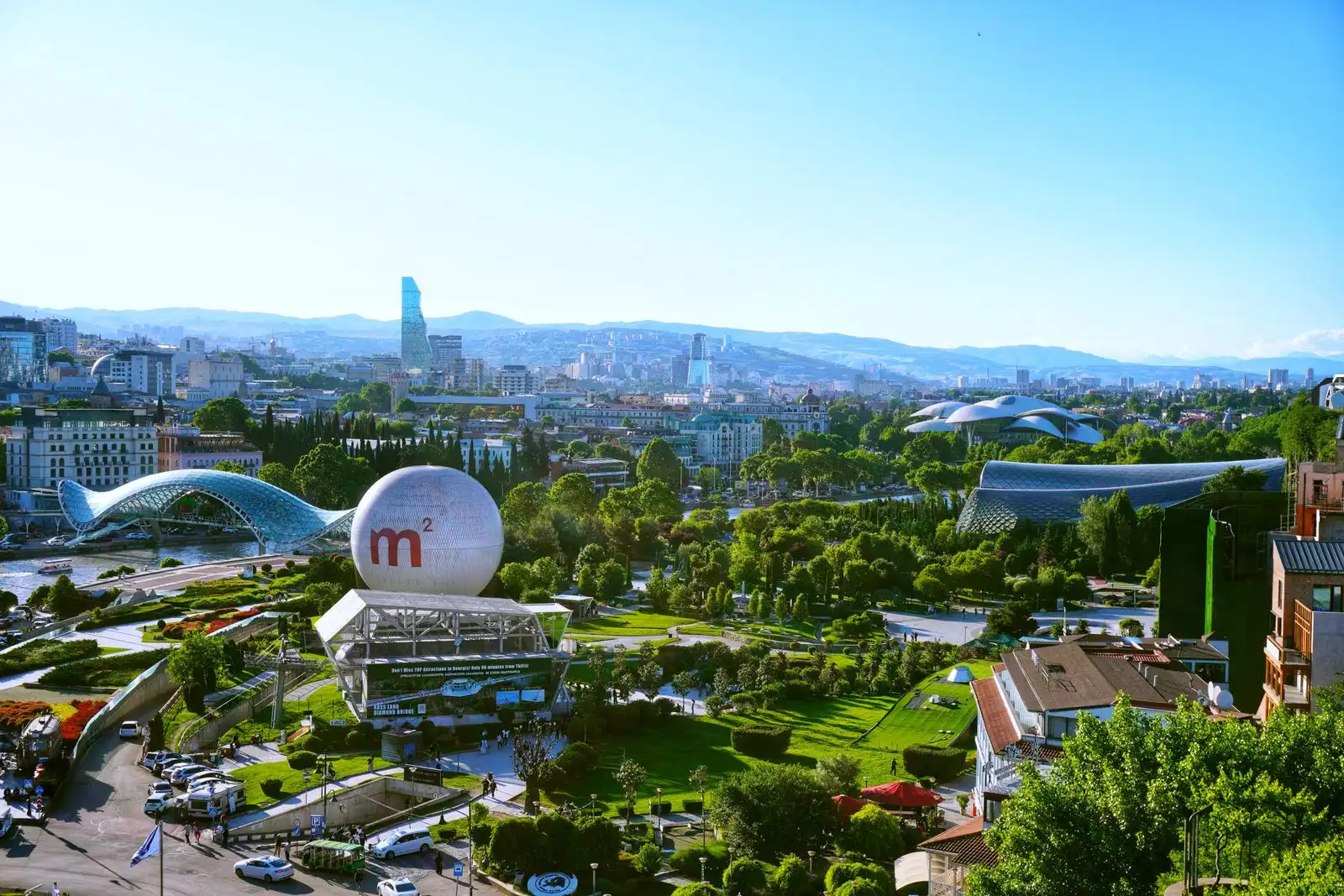 Rike Park and Tbilisi's buildings below the surrounding hills