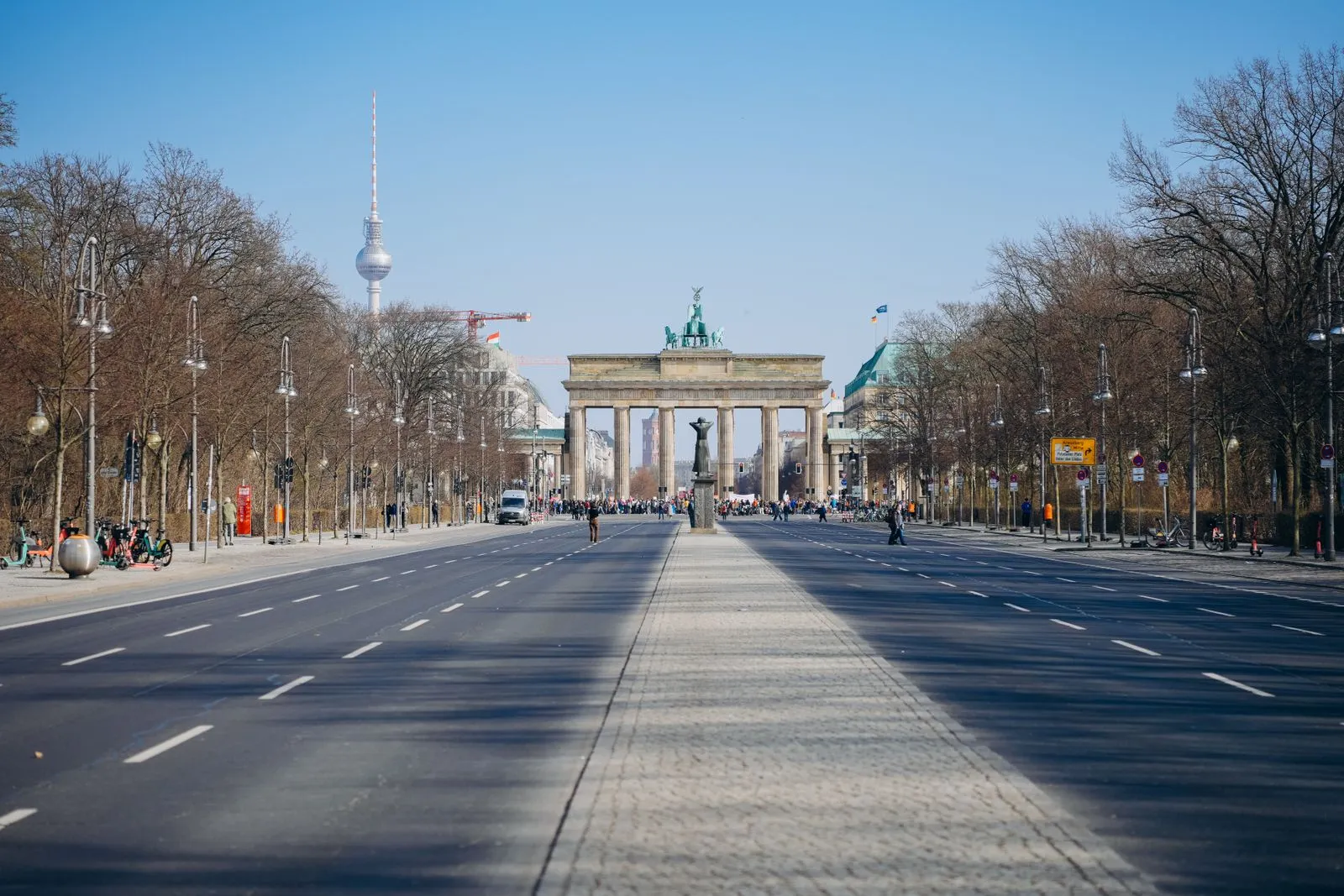 Brandenburg Gate in Berlin seen along a broad avenue, with the TV Tower to the left