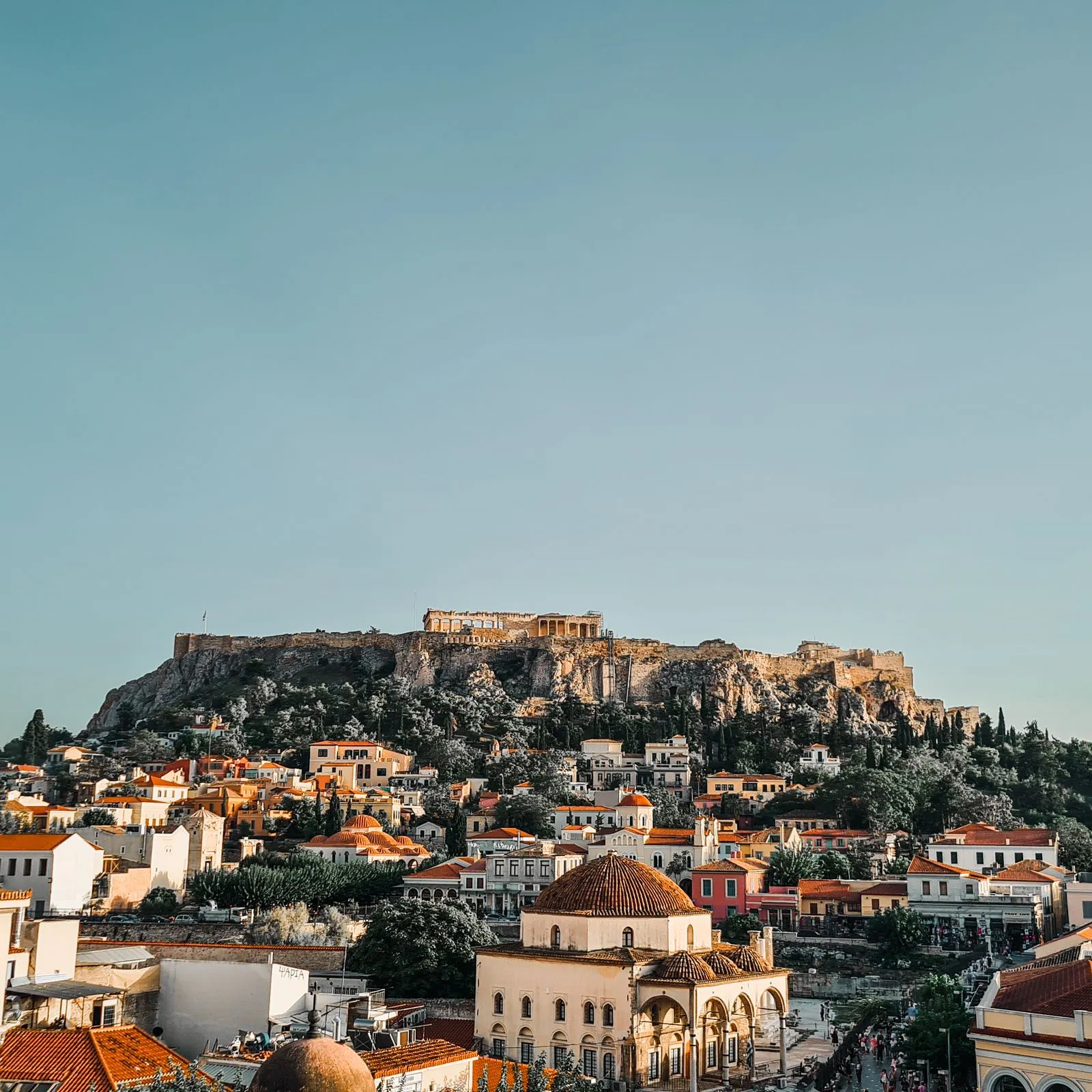 The Acropolis and Parthenon above red rooftops and Monastiraki Square in Athens