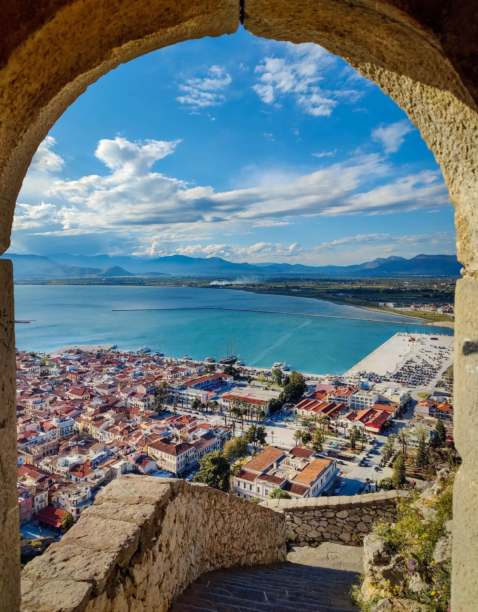 Nafplio and its bay viewed through a stone archway