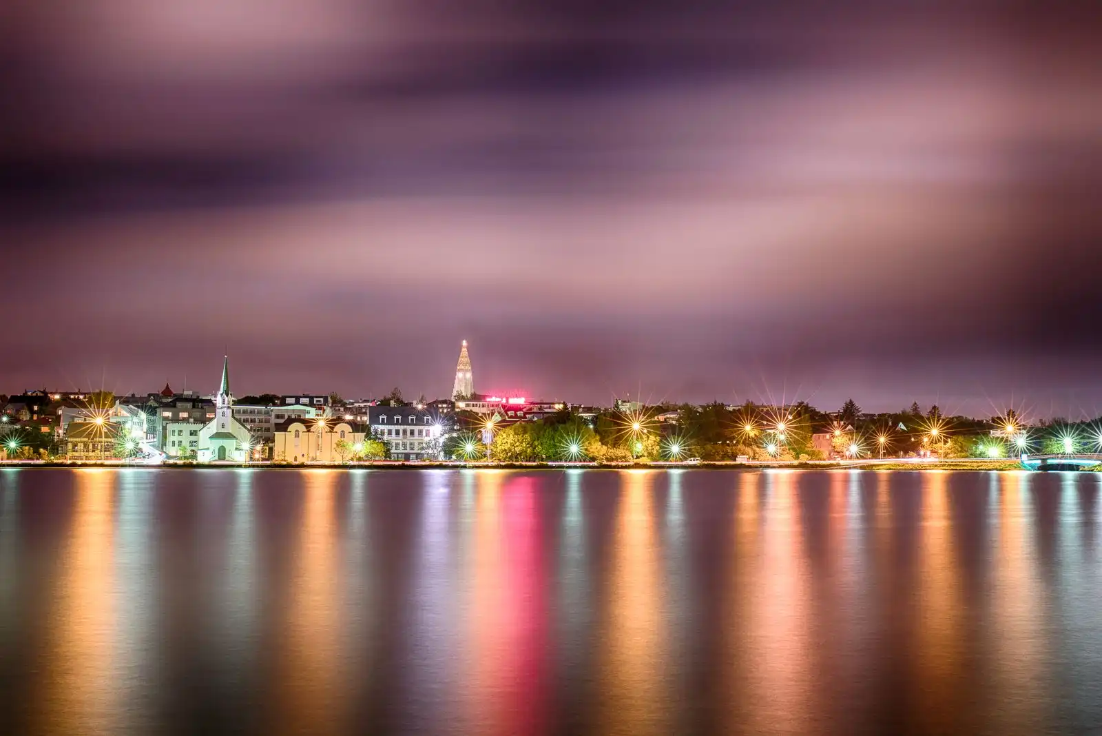 Reykjavík's city lights reflected in the water at night