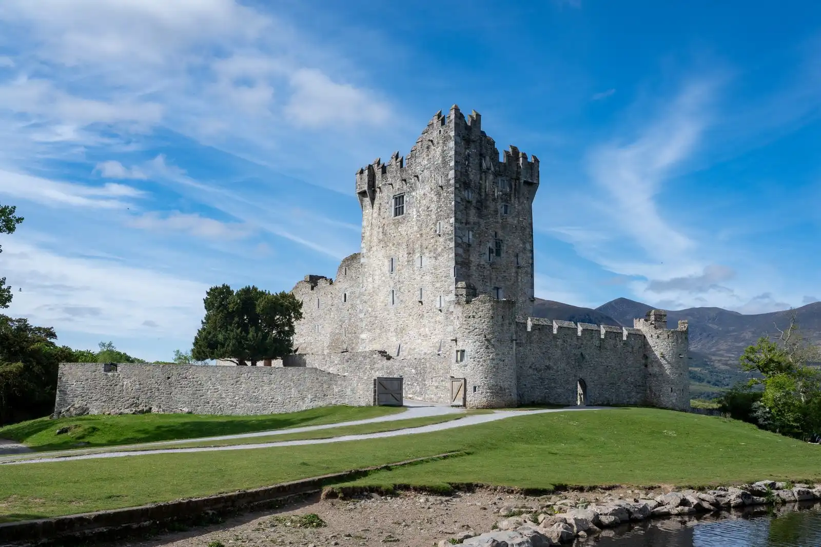 Ross Castle beside green lawns in Killarney