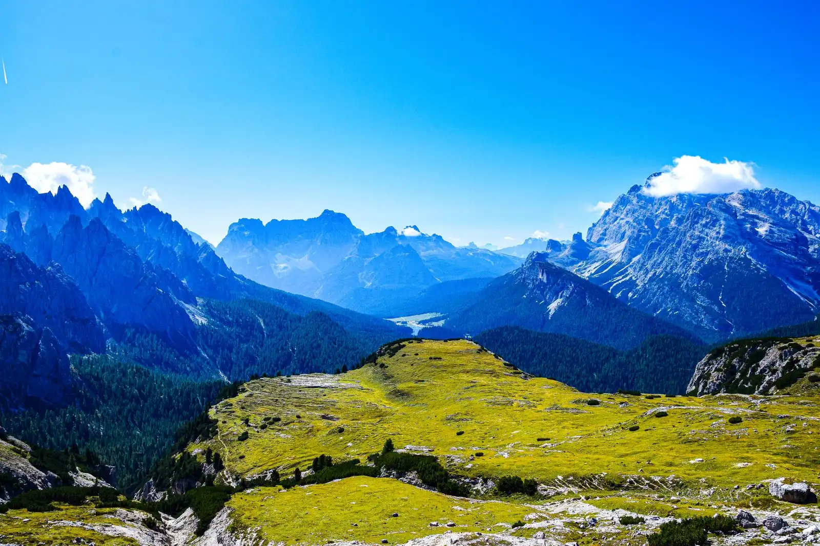 An alpine meadow beneath mountain peaks in the Dolomites