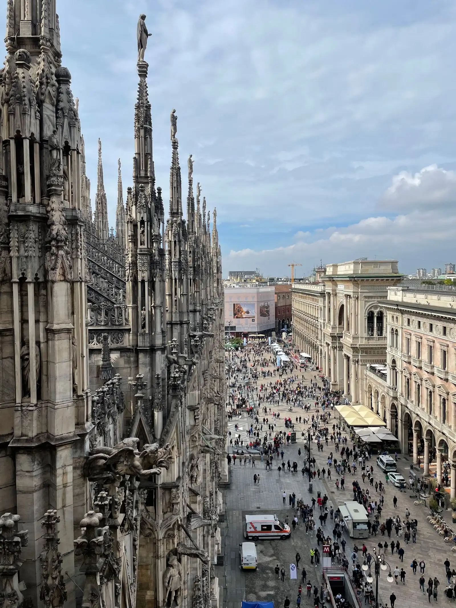 Milan Cathedral beside the buildings and crowds of Piazza del Duomo