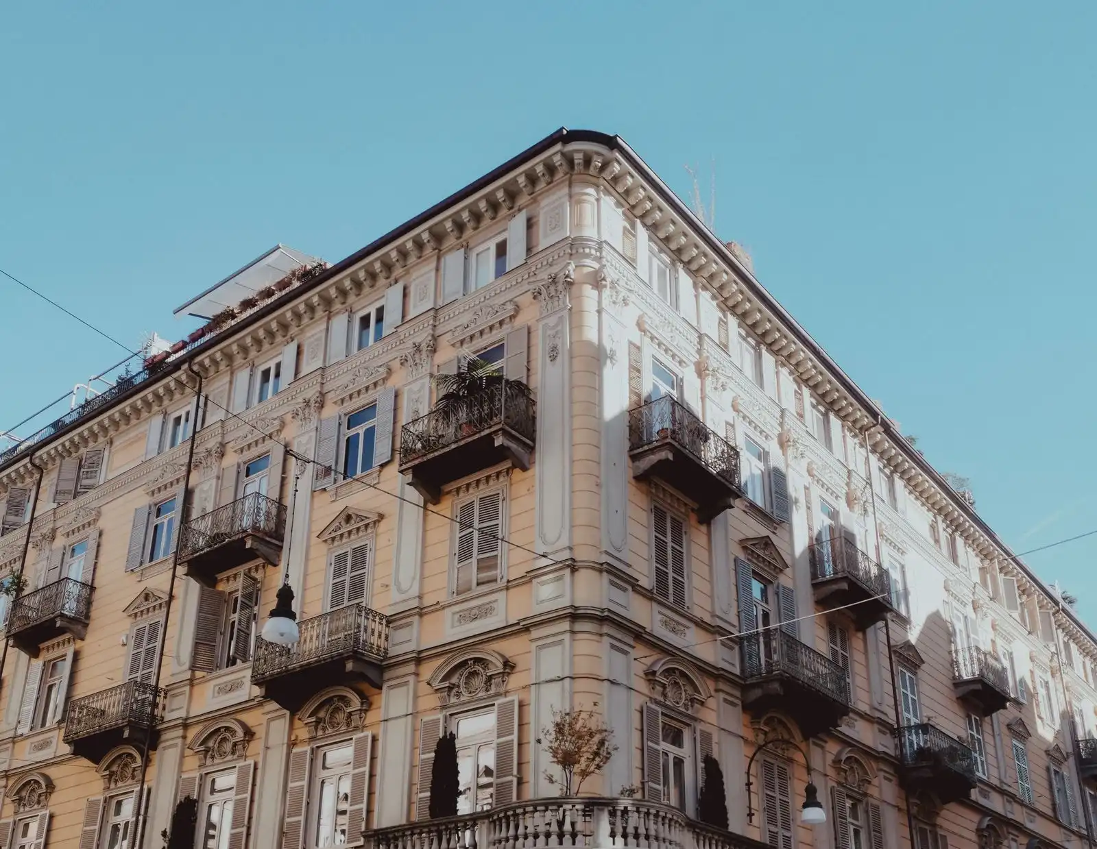 An ornate corner building with balconies in Turin