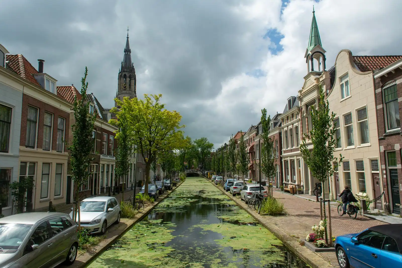 Delft's canal between historic buildings and a church tower