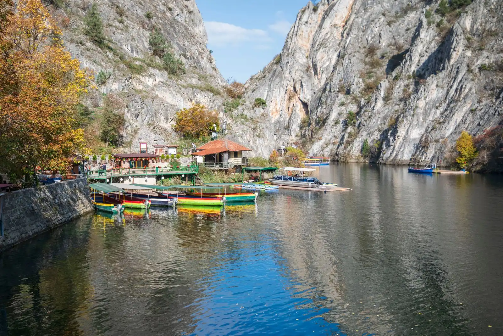 Small boats on the lake below the cliffs of Matka Canyon