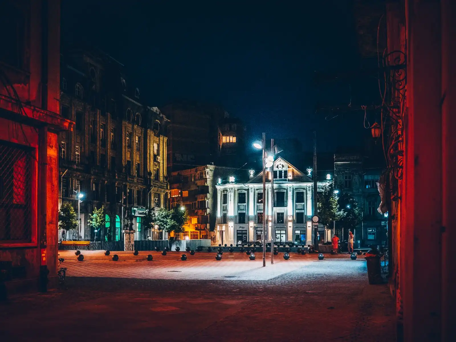 Illuminated buildings on a square in Timișoara at night