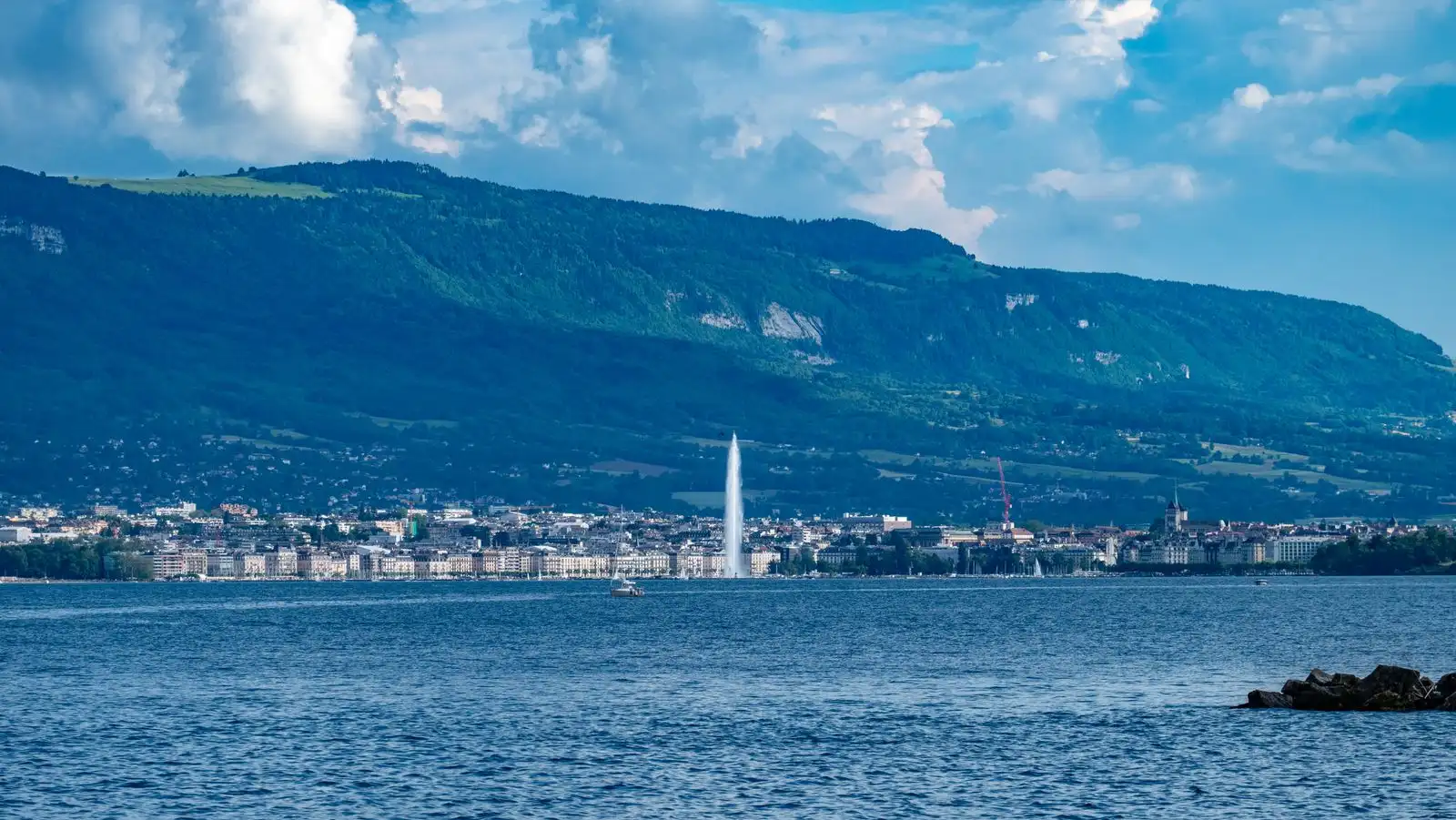 Geneva's waterfront across the lake below distant mountains