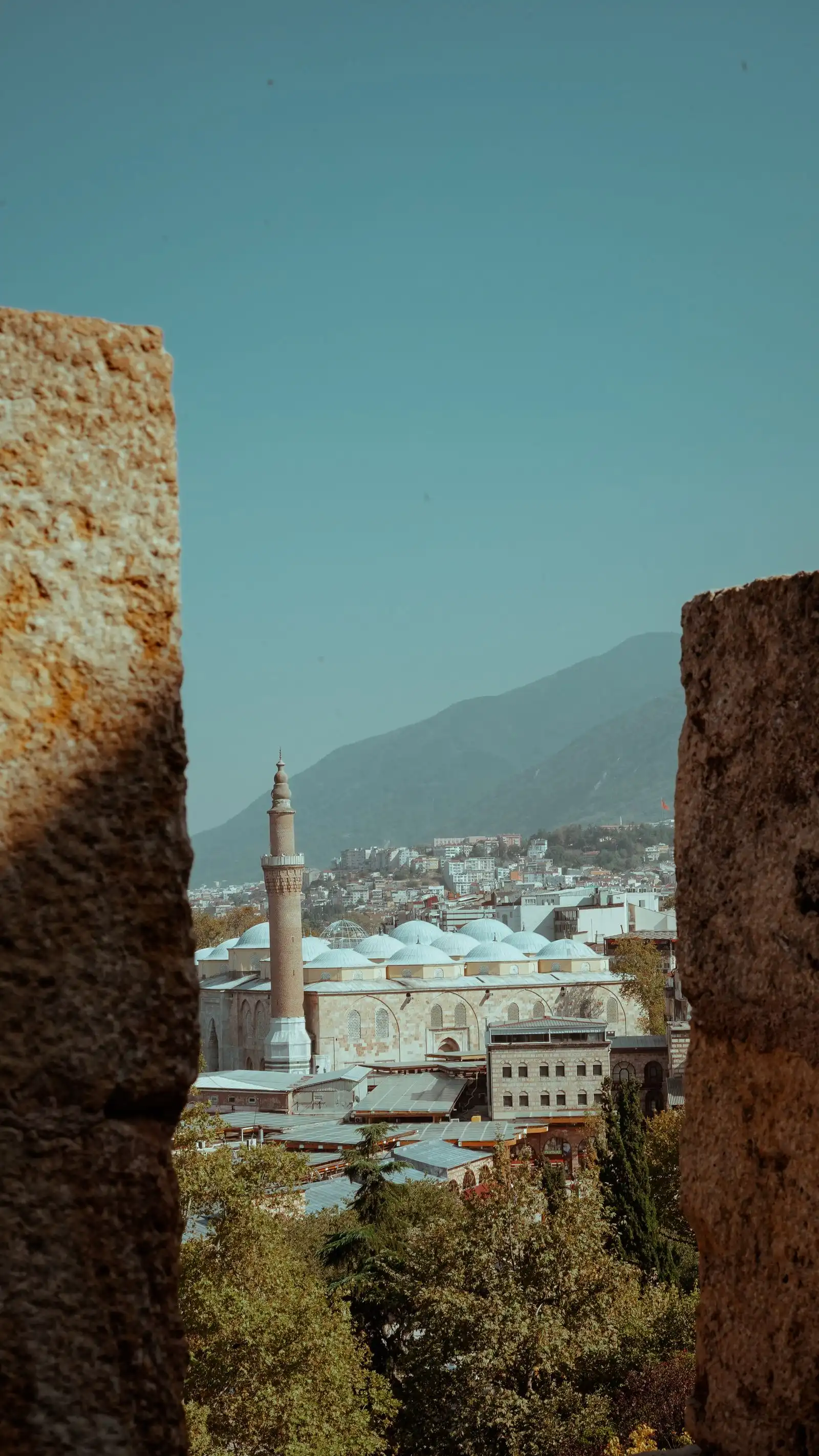 Bursa's buildings and a minaret seen between old stone walls