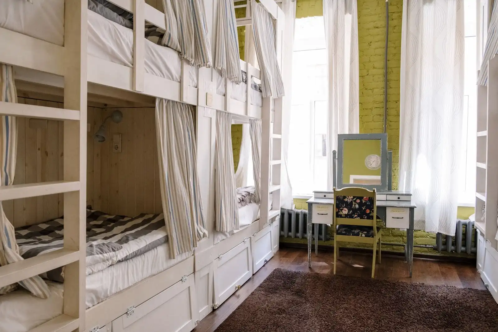 Bunk beds with curtains in a shared hostel room