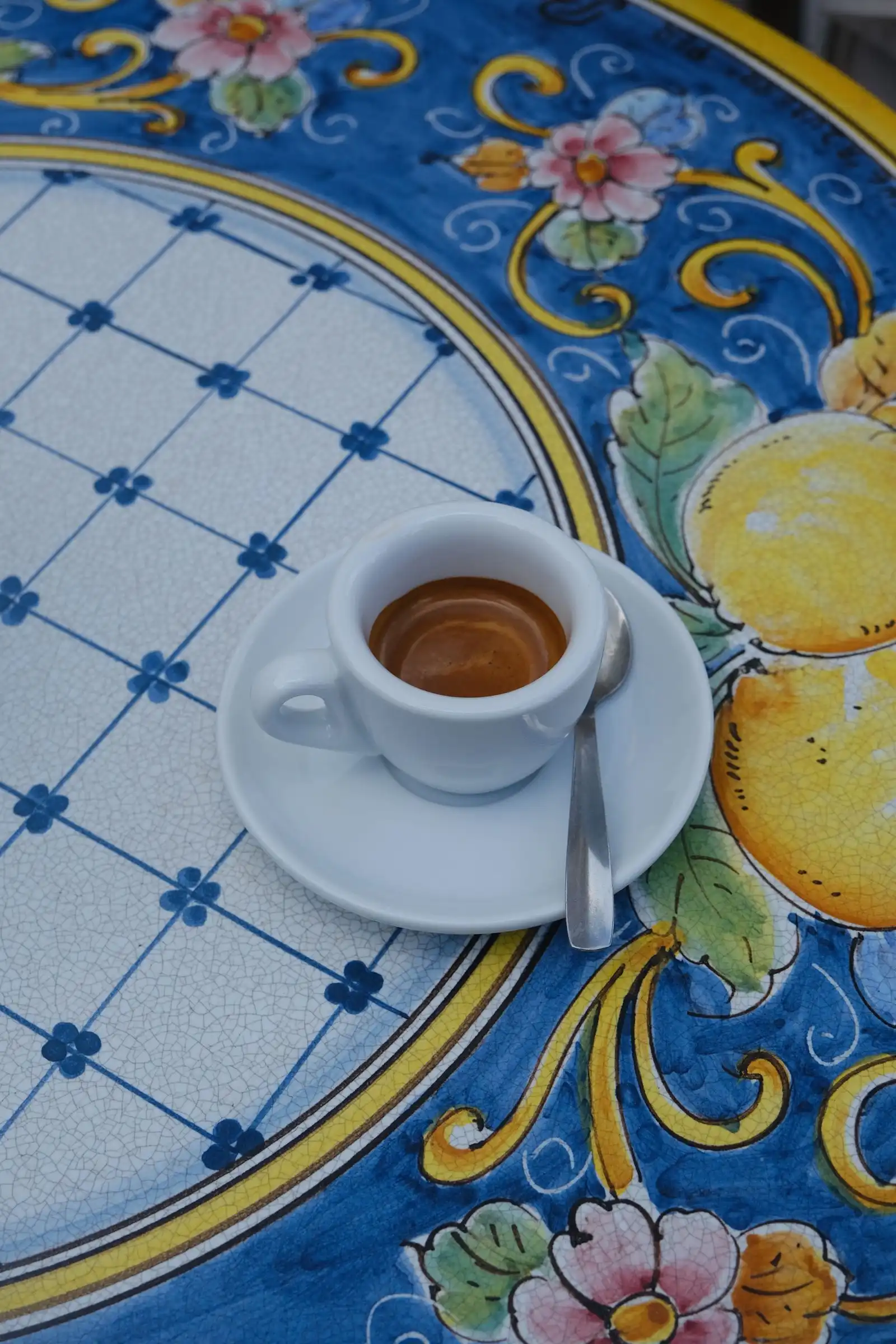 Espresso in a white cup on a patterned ceramic table