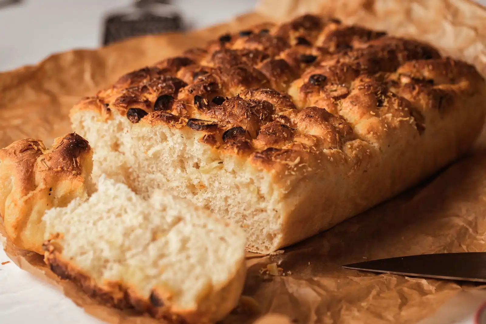 Focaccia bread with a cut slice on paper