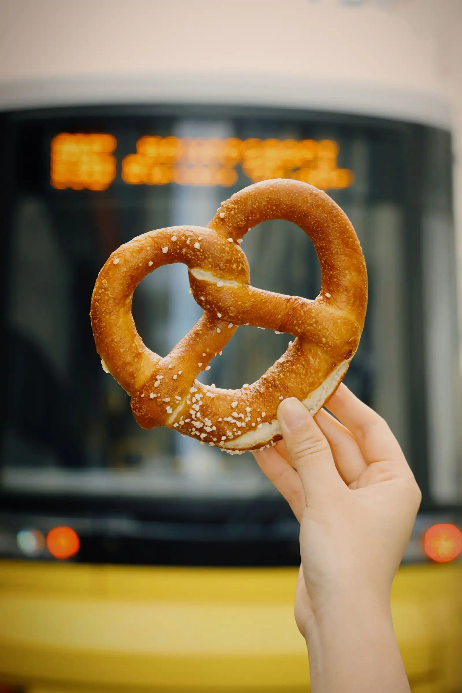 A hand holding a salted pretzel in Berlin