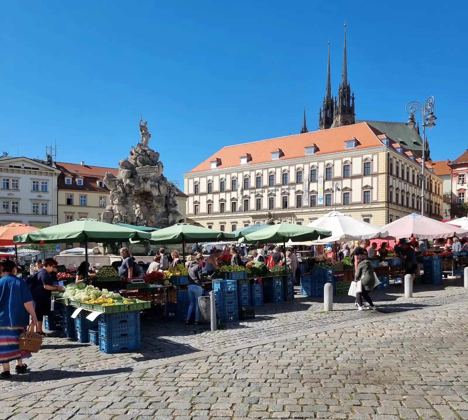 Produce stalls and shoppers in Brno's Zelný trh square
