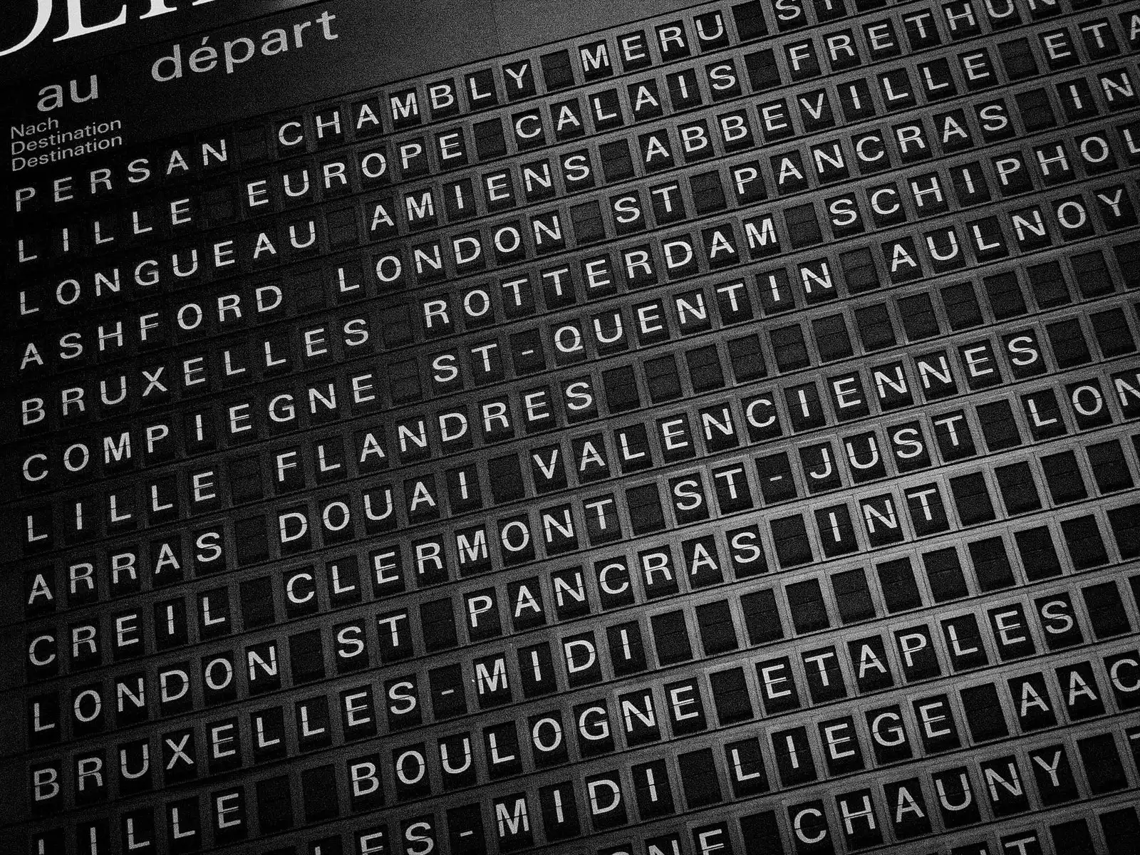 Black and white station departure board showing European destinations