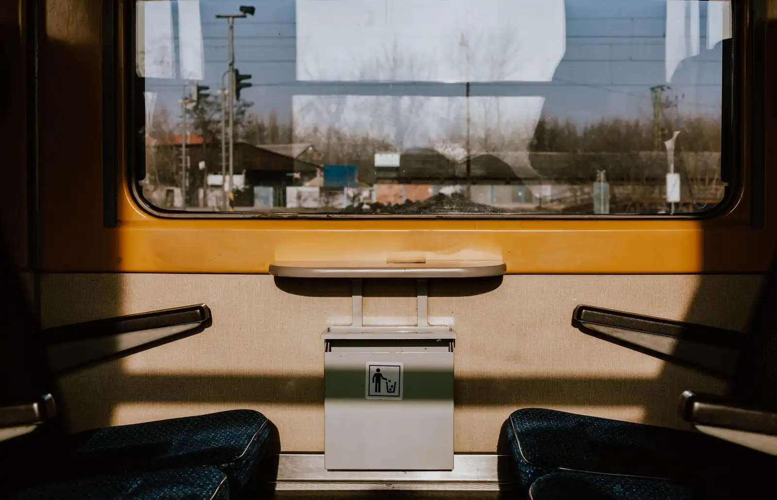 Seats and a small table beside a train compartment window
