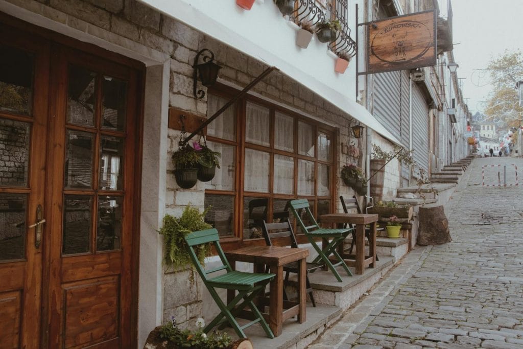 Quaint street scene with outdoor café seating in Gjirokaster, Albania.